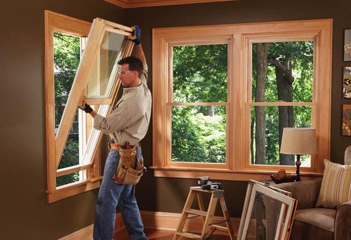 man with toolbelt installing a window