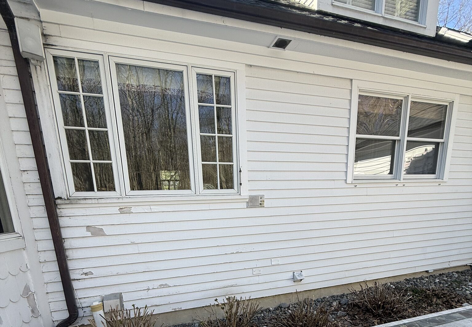 siding repair needed. white siding peeling off, falling off